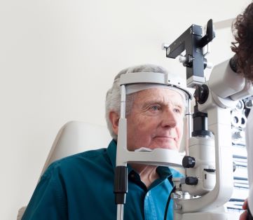 Elderly man in an eye examination for macular degeneration with an ophthalmologist