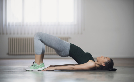 Woman doing a bridge pose as part of pilates workout