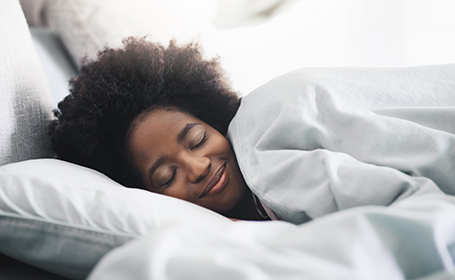 woman happily asleep in bed