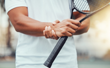 Fit man pausing during a game of tennis due to a painful wrist - why does my wrist hurt?