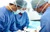 Splenectomy procedure being carried out by three surgeons in the operating theatre